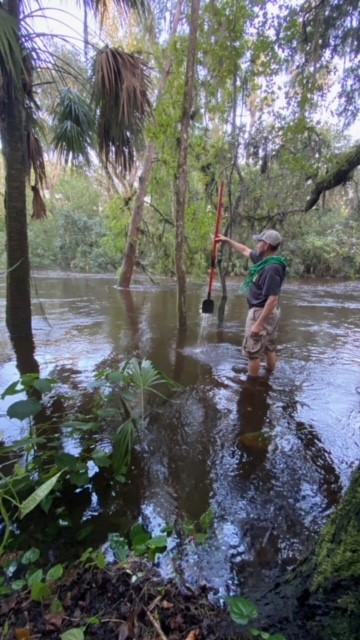 Volunteer standing in flood water doing trail work