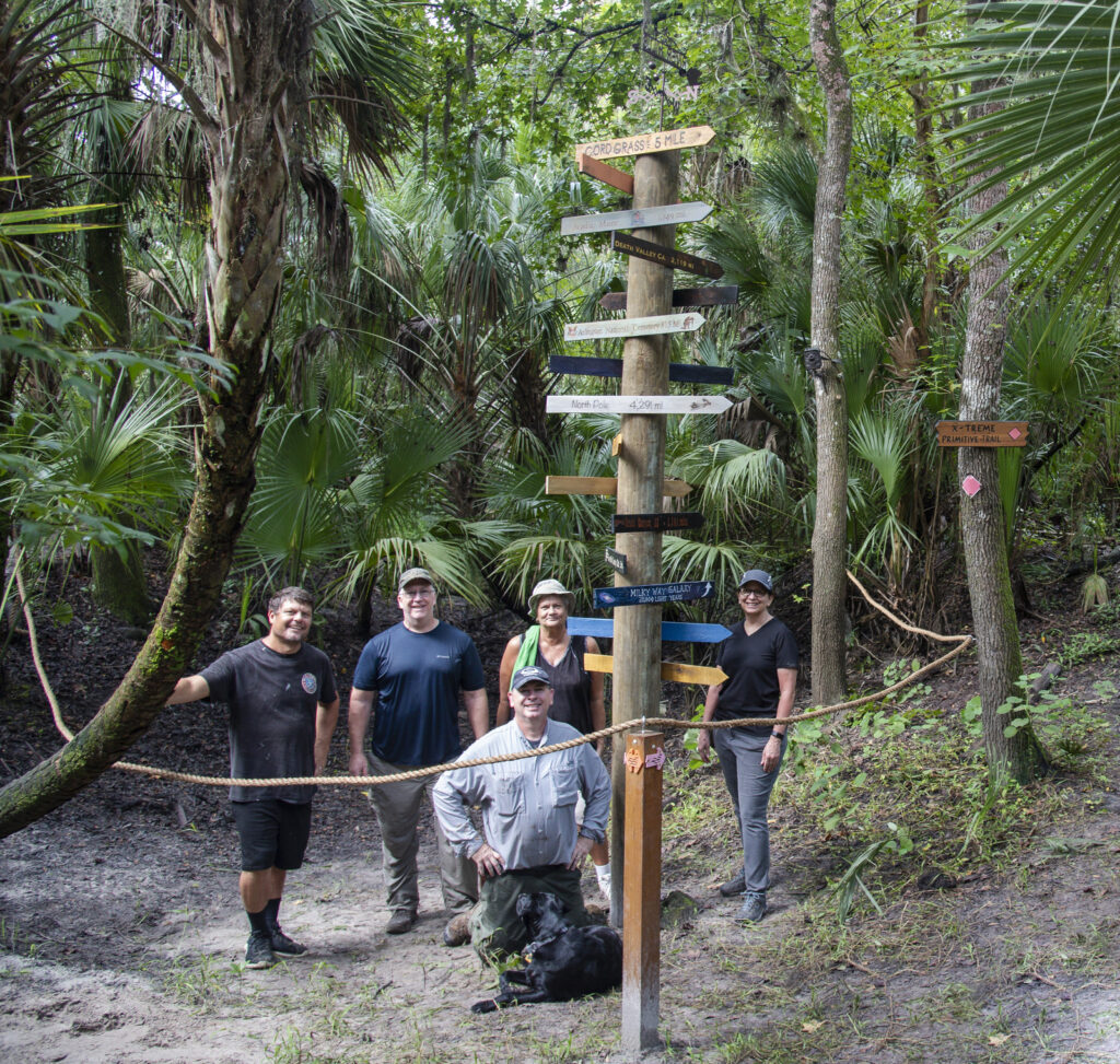 The full volunteer crew posing proudly around the completed landmark pole at Radio Crossing