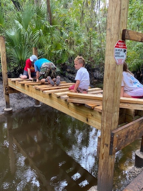 Volunteer posing with the landmark pole as signs are being added