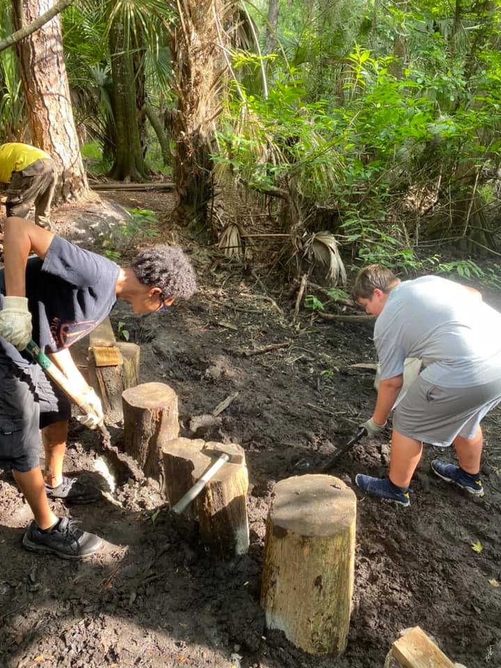 Volunteers digging and reinforcing the cedar stumps with concrete and steel after the first flood event washed out the original crossing